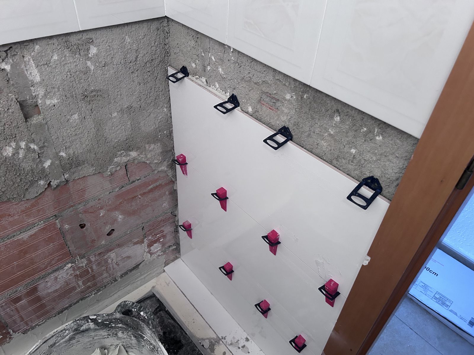 Durante: alicatado nuevo con niveladoras para dejar la pared recta.